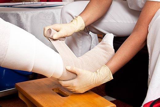 Wound care in Douglasville, as CNA dresses a leg wound with bandages